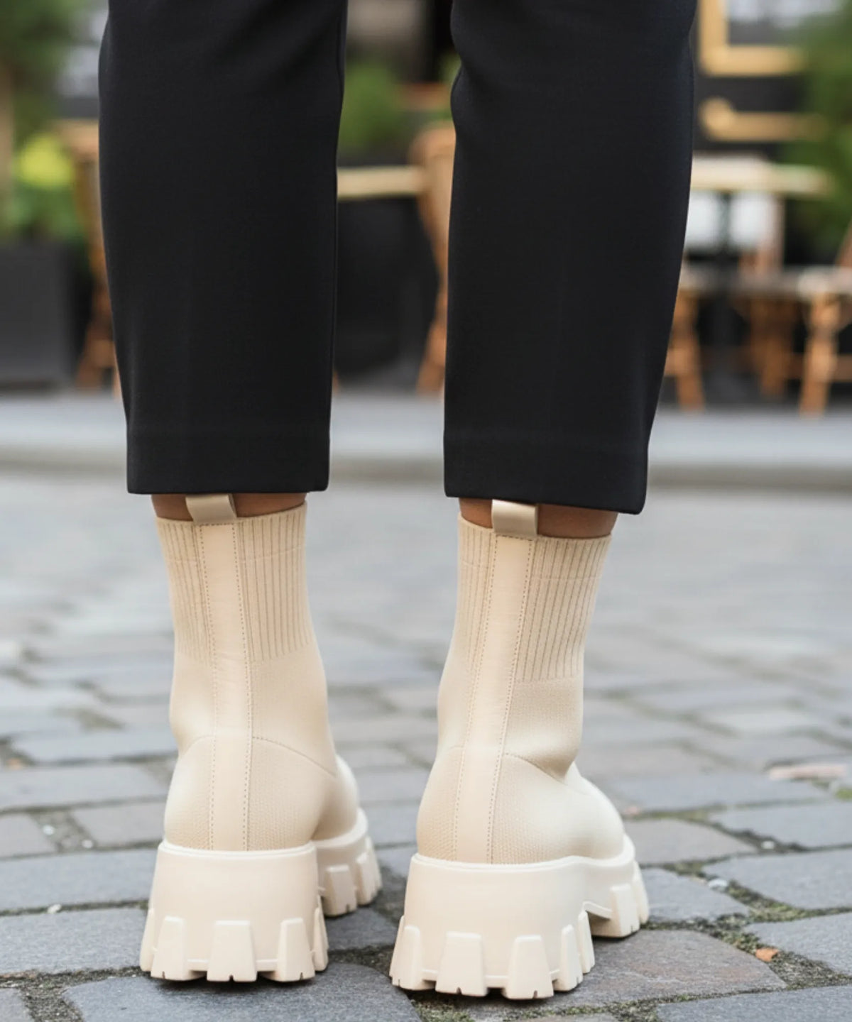 Elfenbensvit dam sockstövel stylas med raka jeans och oversized kappa