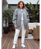 Helkroppsvy av dam i charcoal oversized bouclé bomberjacka