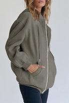 Dam i rosa oversized hoodie med sänkta axlar och långa ärmar